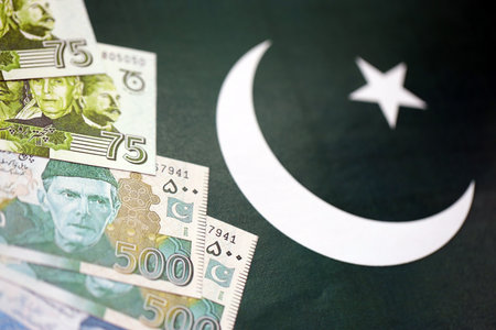 Pakistan rupees banknotes on Pakistani flag background. The current Pakistan money bills lies on banner in big amount. The concept of economics and business in Pakistanの写真素材