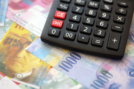 Swiss franc banknotes and calculator. The current francs money bills and calc lies on table in big amount. The concept of taxation and money count in Switzerlandの写真素材