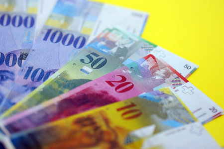 Swiss franc banknotes on yellow. The current francs money bills lies on table in big amount. The concept of business and investment in Switzerlandの写真素材