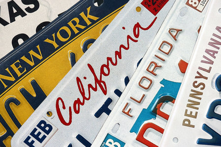 Old US car license plates with various state names close up. Concept of driving in United States. Reaching a car registrationの写真素材
