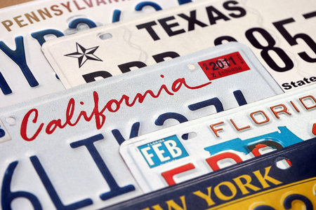 Old US car license plates with various state names close up. Concept of driving in United States....