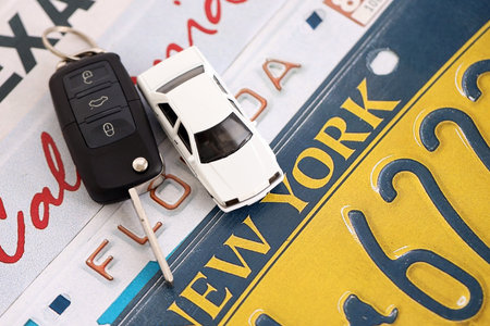 Remote control car keys on US license plates with state names close up. Concept of driving in United States. Reaching a car registrationの写真素材