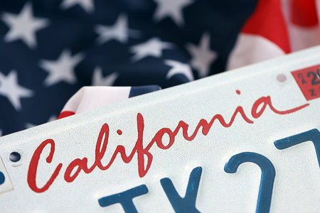 USA state of California license plate on US flag. Concept of driving in California. Reaching a...