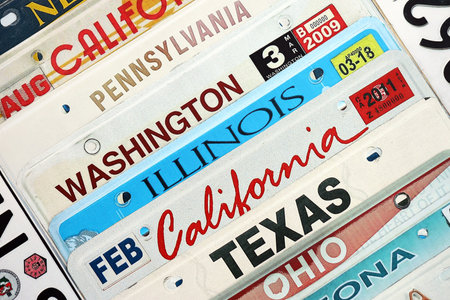 Old US car license plates with various state names. Concept of driving in United States. Reaching a car registrationの写真素材
