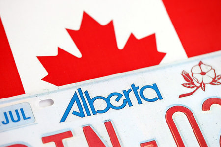 Alberta canadian car license plate on flag of Canada close up. Driving permit and registration conceptの写真素材