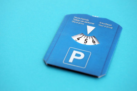 Parking disc for windshield. Limited time parking system in european countries. Concept of parking time count in busy parking lotsの写真素材