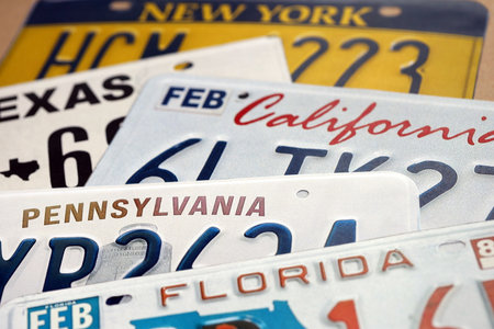 Old US car license plates with various state names close up. Concept of driving in United States. Reaching a car registrationの写真素材