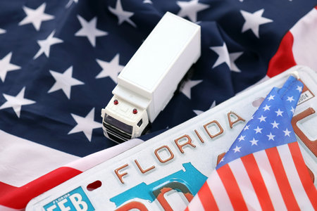 Toy truck and USA state of Florida license plate on US flag. Concept of driving in Florida. Reaching a driving permitの写真素材