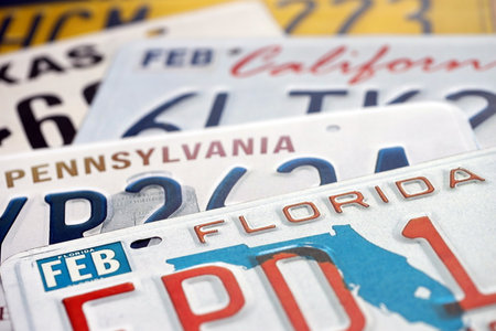 Old US car license plates with various state names close up. Concept of driving in United States....