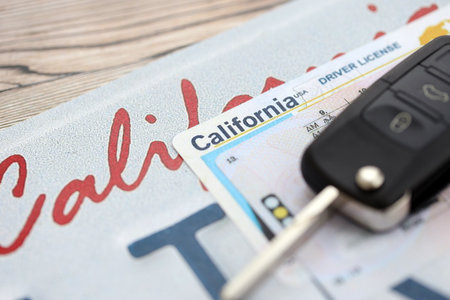 Remote control car keys on California license plate with driver license. Concept of driving in California. Reaching a driving permitの写真素材