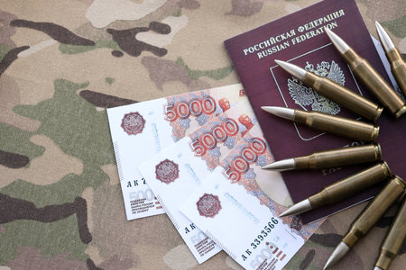 Russian money with bullets on passport and multicam camouflage fabric close up.の写真素材