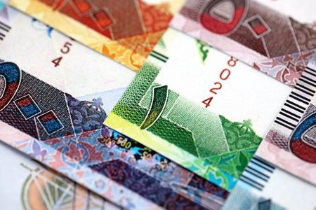 Qatari riyal money bills banknotes lies in big pile on table close up. Concept of finances and...