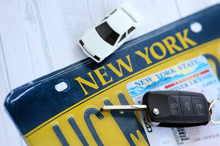 Remote control car keys on New York license plate with driver license. Concept of driving in New York. Reaching a driving permitの写真素材