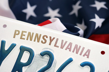 USA state of Pennsylvania license plate on US flag. Concept of driving in Pennsylvania. Reaching a driving permitの写真素材