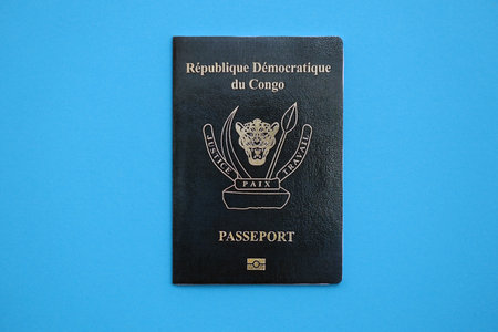 Democratic Republic of Congo passport on light blue table background close up. Concept of travel and...