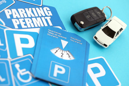 Parking permit paper notice tag and parking disc with ignition keys and toy car. Parking permit for people with disabilities conceptの写真素材