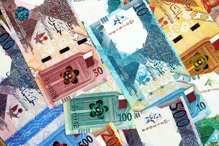 Qatari riyal money bills banknotes lies in big pile on table close up. Concept of finances and...
