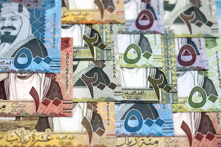 Saudi Arabia riyal money bills banknotes lies in big pile on table close up. Concept of finances and...
