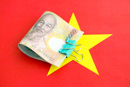 Vietnamese dong currency money bills lies on flag close up. The concept of business and investmentの写真素材