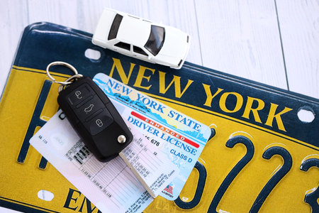 Remote control car keys on New York license plate with driver license. Concept of driving in New York. Reaching a driving permitの写真素材