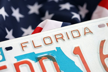 USA state of Florida license plate on US flag. Concept of driving in Florida. Reaching a driving permitの写真素材