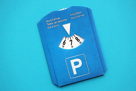 Parking disc for windshield. Limited time parking system in european countries. Concept of parking time count in busy parking lotsの写真素材