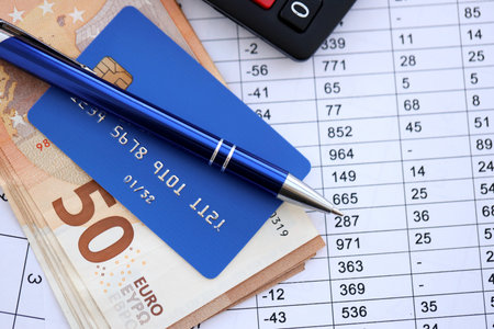 Credit card and pen with euro currency money bills banknotes on calculations document background. Business, financial operations and accounting in European Unionの写真素材
