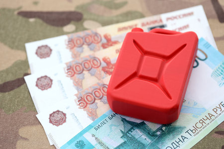 Petrol canister on russian roubles money bills on camouflage fabric. Concept of petroleum export from Russiaの写真素材