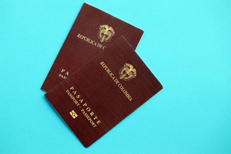 Two colombian passports on light blue table background. Concept of citizenship of Republic Colombiaの写真素材