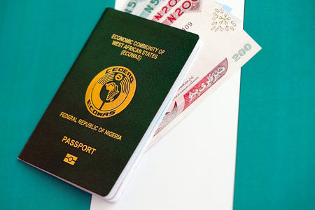 Nigerian naira currency money bills and passport lies on flag close up. The concept of travel and vacationの写真素材