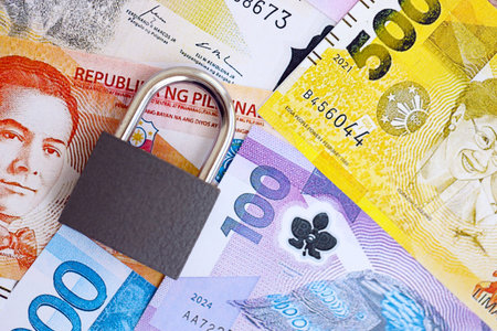 Philippines peso currency money bills and padlock close up. The concept of sanctions and financial safetyの写真素材