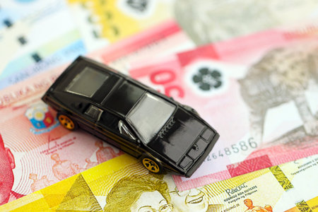 Philippines peso currency money bills and toy car close up. The concept of car ownershipの写真素材
