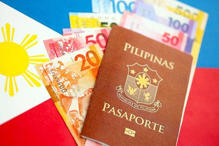 Philippines peso currency money bills and passport lies on flag close up. The concept of travel and vacationの写真素材