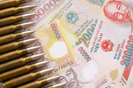 Vietnamese dong currency money bills and rifle bullets close up.の写真素材