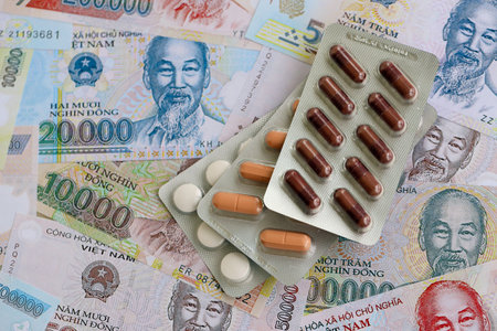 Vietnamese dong currency money bills and medicine pills close up. The concept of medicine and pharmacyの写真素材