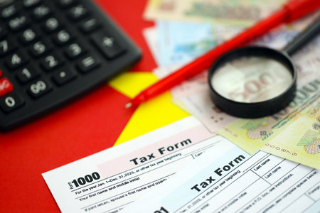 Vietnamese dong money bills and calculator with tax form on flag close up. Taxation and accounting conceptの写真素材