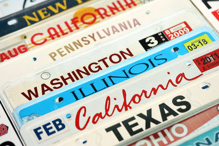 Old US car license plates with various state names. Concept of driving in United States. Reaching a car registrationの写真素材