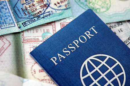 Many open passport pages with lots of visas and entrance stamps from various countries passport control. Concept of travel and tourism worldwideの写真素材