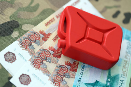 Petrol canister on russian roubles money bills on camouflage fabric. Concept of petroleum export from Russiaの写真素材