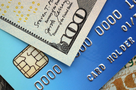 One hundred US dollar bill banknote on blue credit card for banking and payments. Concept of business and bank serviceの写真素材