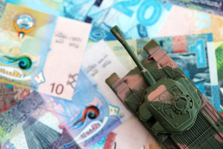 Kuwaiti dinar currency money bills and toy tank close up. The concept of army funds and weapons salesの写真素材