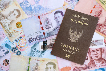 Thai baht currency money bills and passport close up. The concept of travel and vacationの写真素材