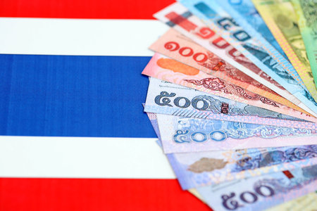 Thai baht currency money bills lies on flag close up. The concept of business and investmentの写真素材