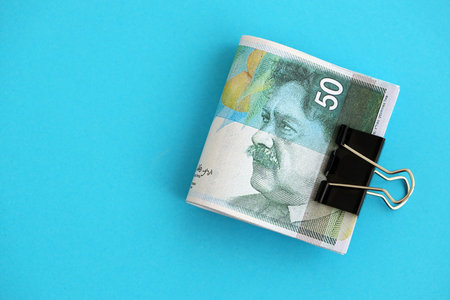 Israel New Shekels banknotes on blue background. The current Israel money bills lies on blue in big amount. The concept of business and investmentの写真素材