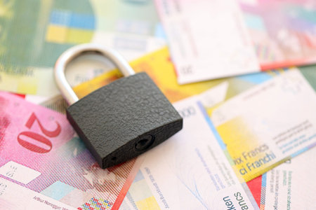 Swiss franc banknotes and padlock. The current francs money bills with lock lies on table in big amount. The concept of sanctions and financial safety in Switzerlandの写真素材
