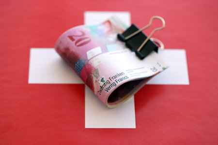 Swiss franc banknotes and flag. The current francs money bills lies on flag in big amount. The concept of business in Switzerlandの写真素材