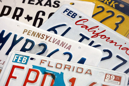 Old US car license plates with various state names close up. Concept of driving in United States. Reaching a car registrationの写真素材