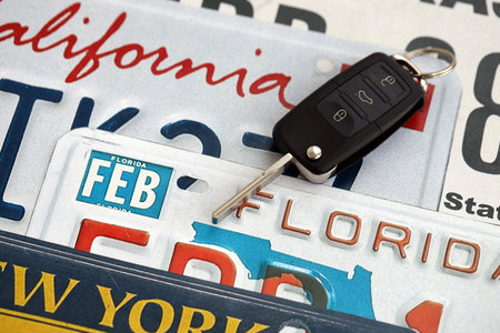 Remote control car keys on US license plates with state names close up. Concept of driving in United States. Reaching a car registrationの写真素材