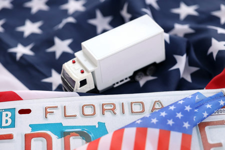 Toy truck and USA state of Florida license plate on US flag. Concept of driving in Florida. Reaching a driving permitの写真素材