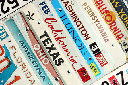 Old US car license plates with various state names. Concept of driving in United States. Reaching a car registrationの写真素材